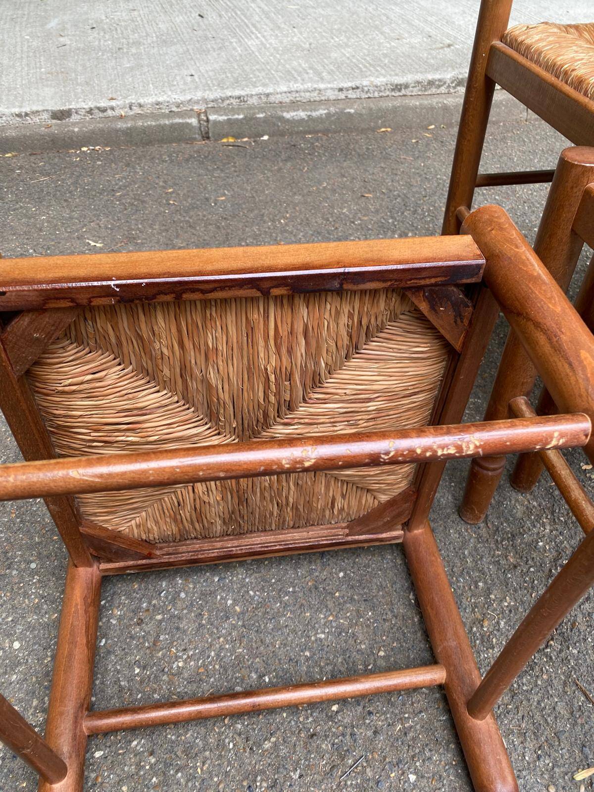 4 solid wood kitchen chairs with straw seats in a country farmhouse style.