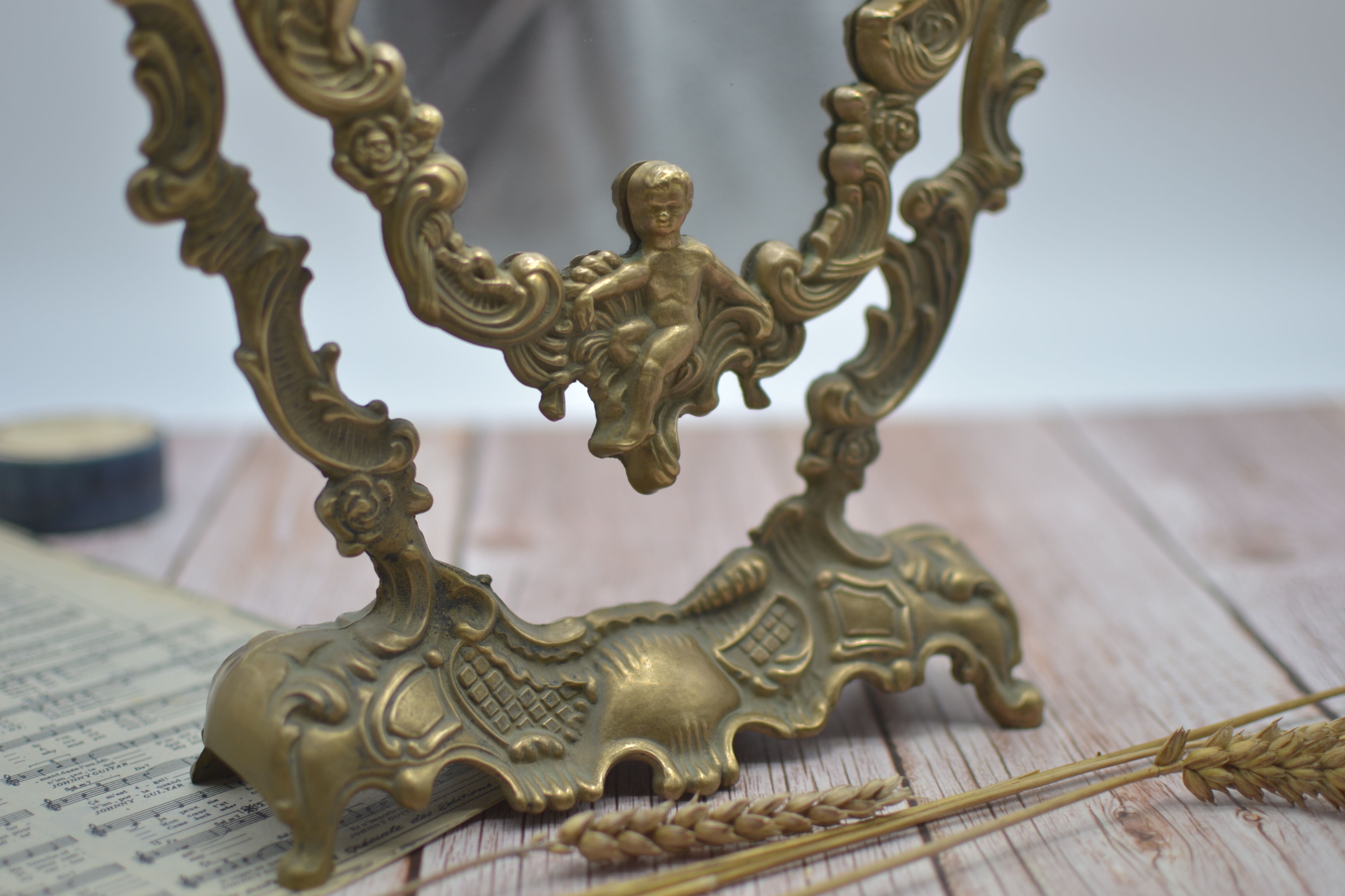 Adjustable psyche mirror of 33 centimeters in gilded bronze with angel ornament