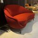 Two-seater sofa in red/orange boucle fabric.