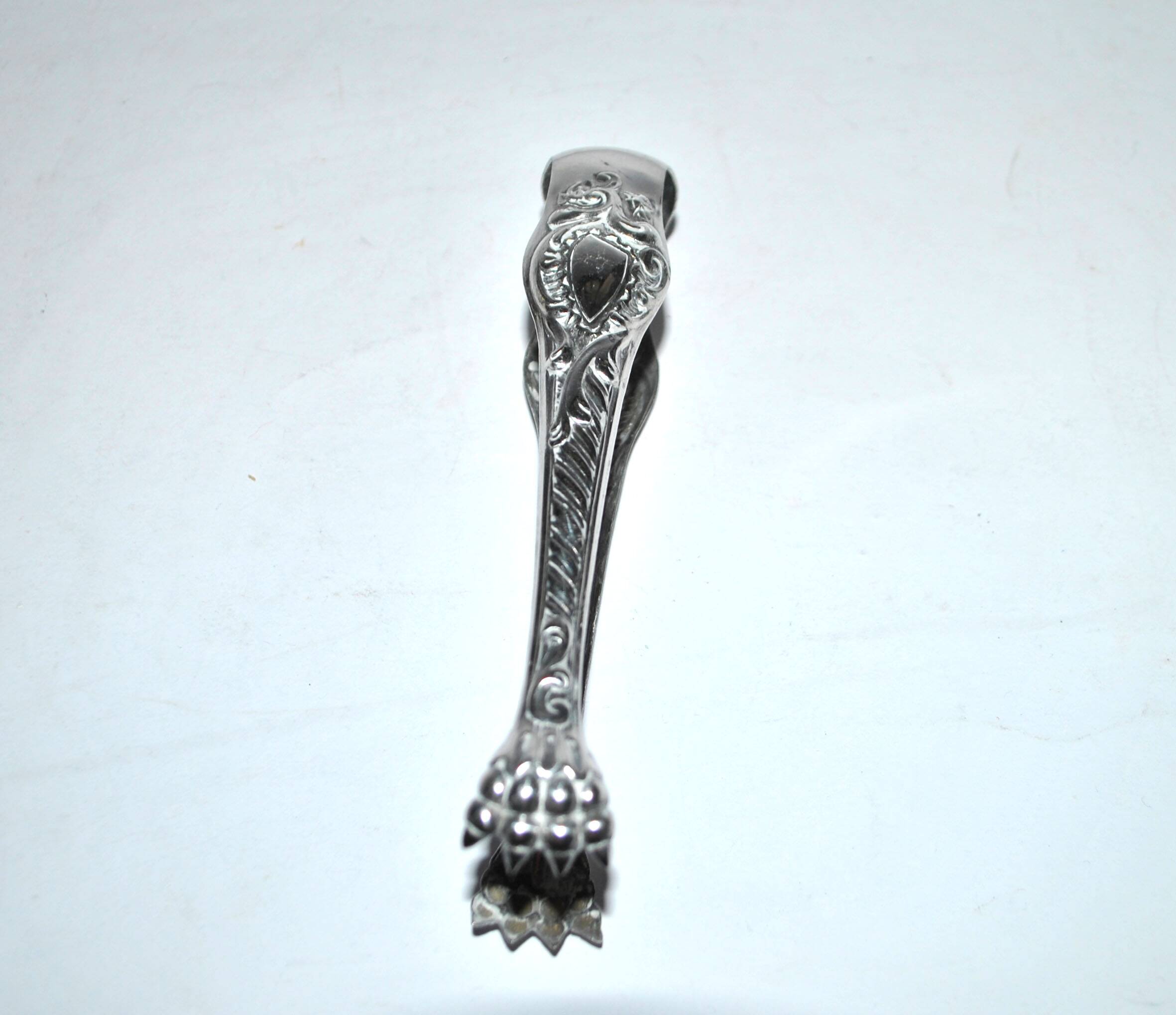 Rocaille sugar tongs in silver metal with lion claw medallion
