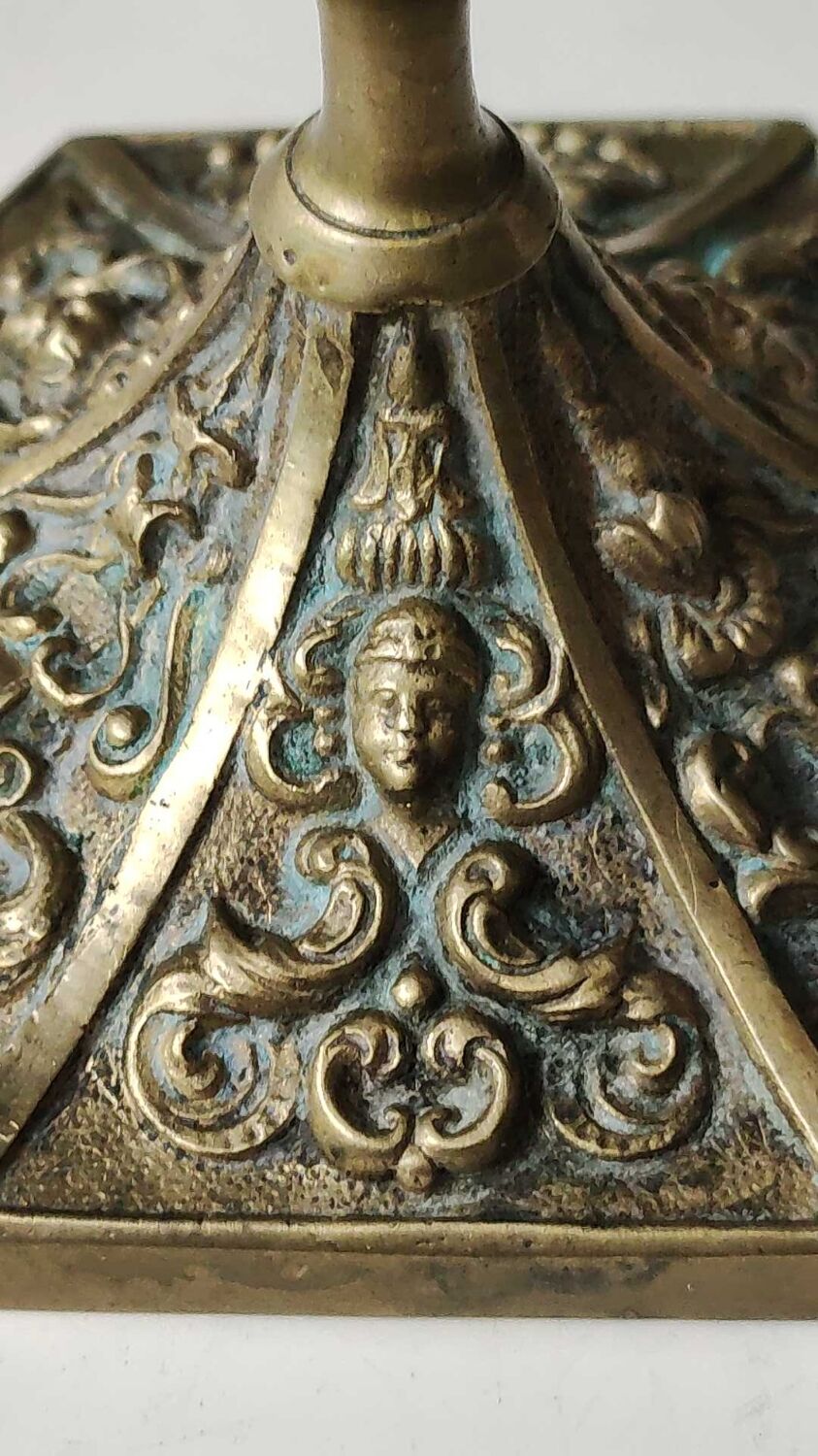 Baroque/Antique style torch candleholder, nineteenth, gilded bronze. Head motifs, volute arabesques