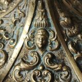 Baroque/Antique style torch candleholder, nineteenth, gilded bronze. Head motifs, volute arabesques