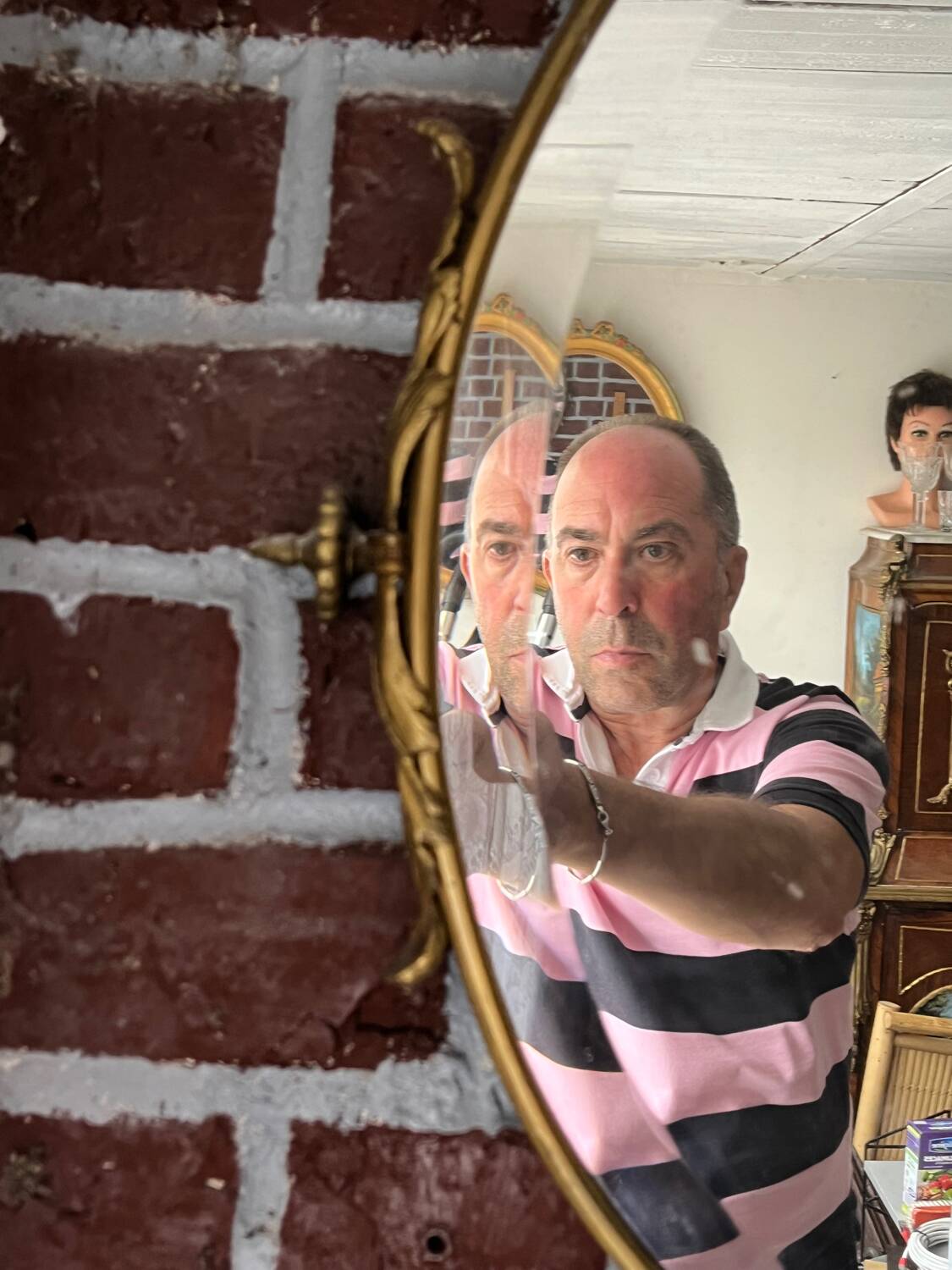 Beveled oval mirror in gilded bronze