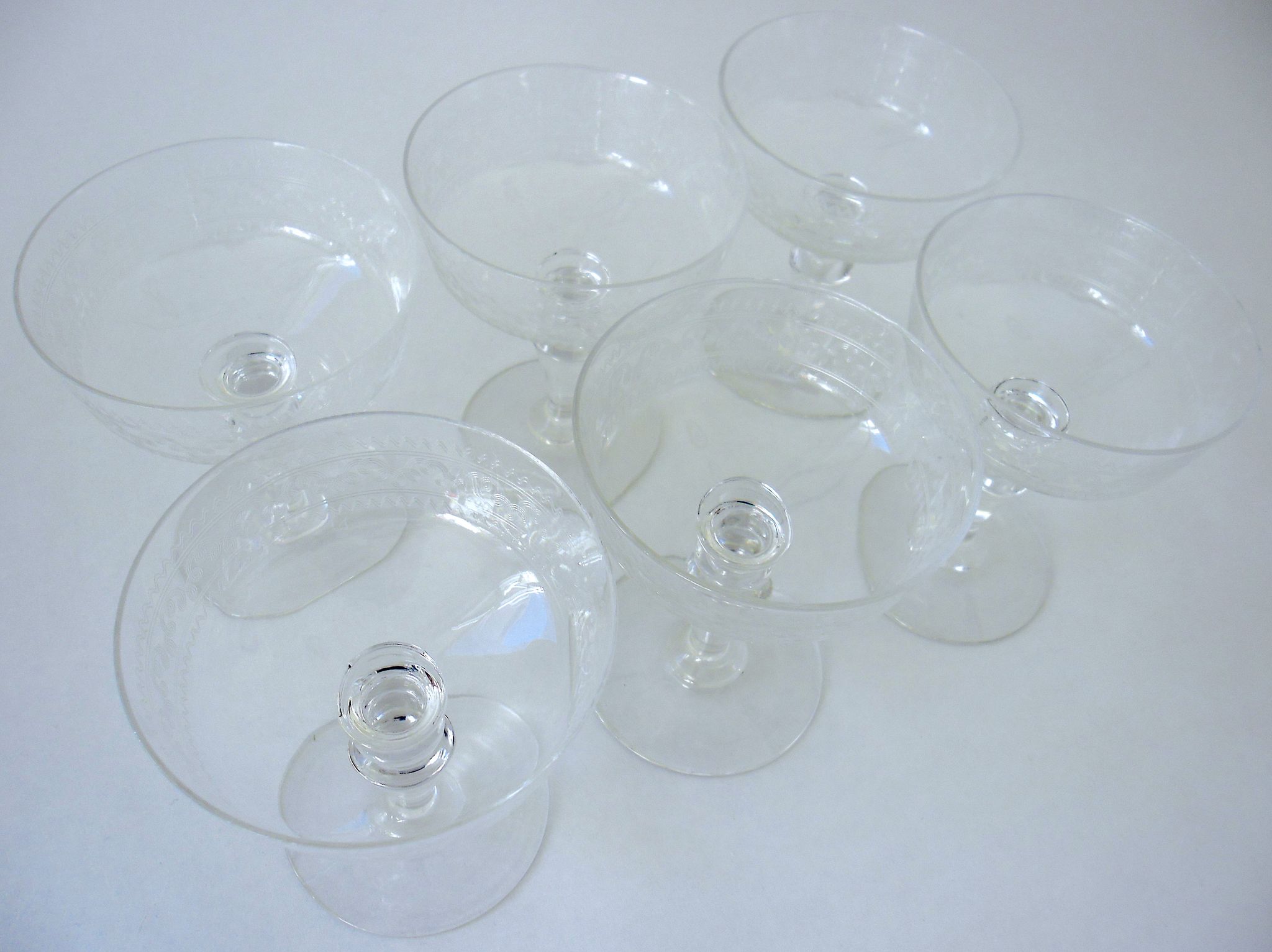 Suite of six champagne glasses on foot in engraved colorless crystal