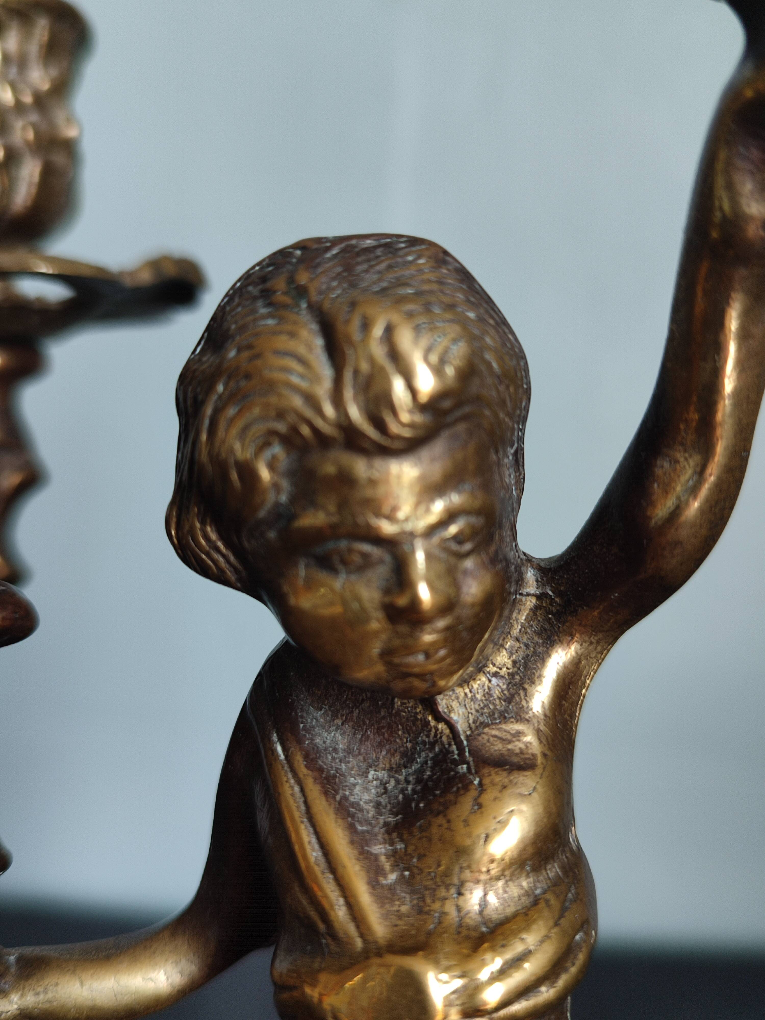 Pair of antique candlesticks in cherub bronze