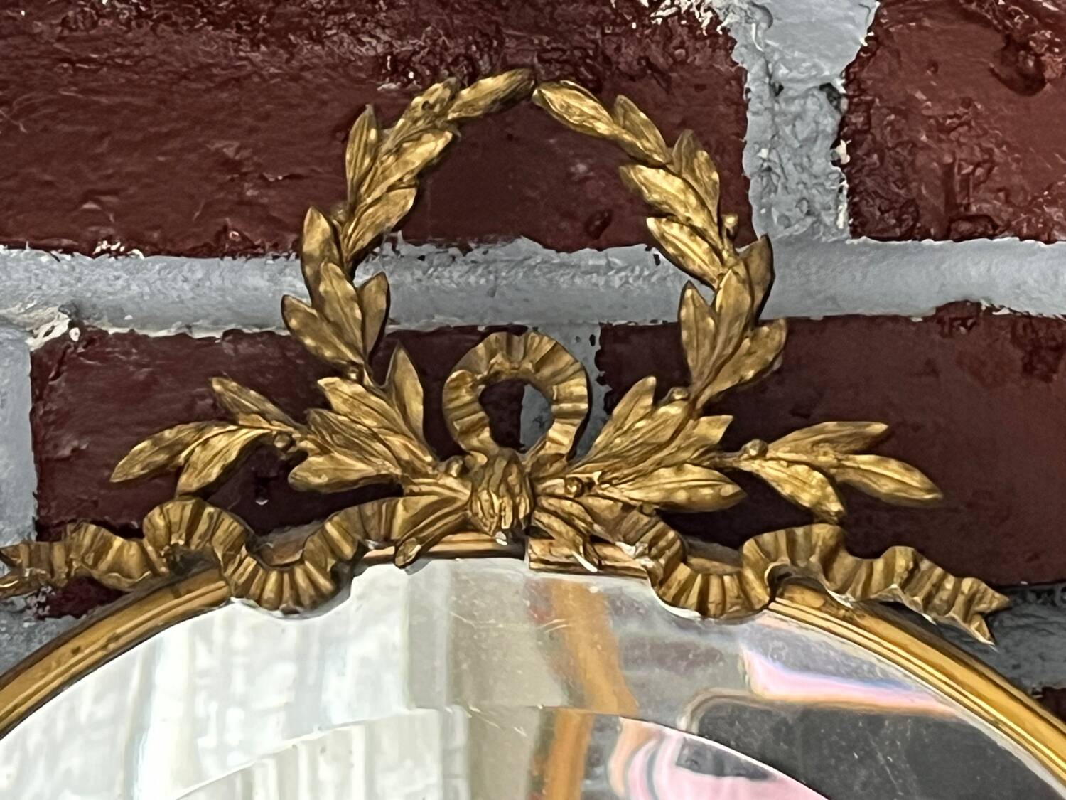 Beveled oval mirror in gilded bronze