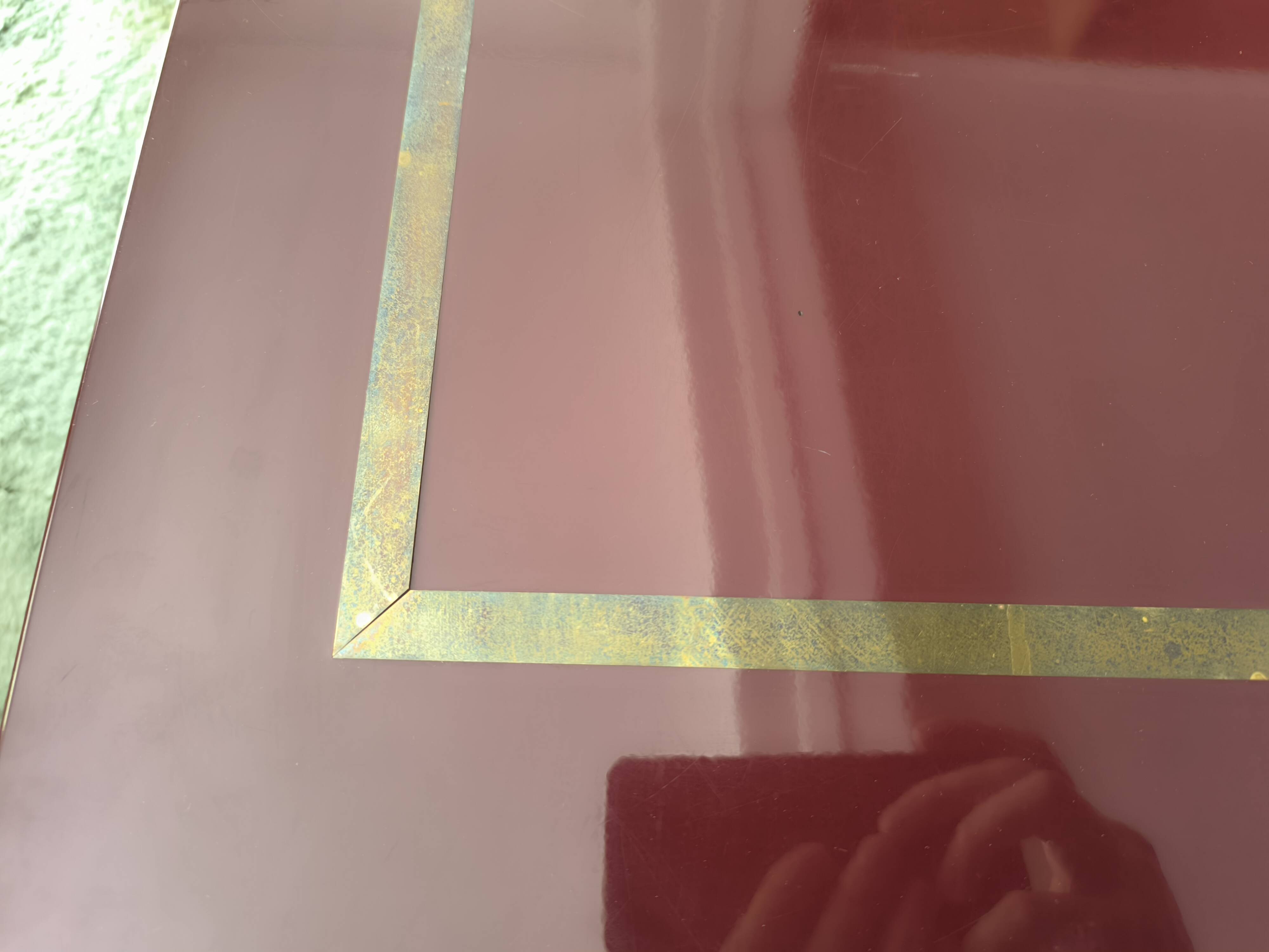Burgundy lacquered coffee table with brass by Jean-Claude Mahey.