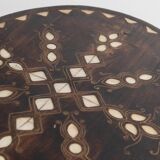 Vintage side table from the early 19th century, dark wood with mother-of-pearl inlays, oval shape with three legs, ethnic style.