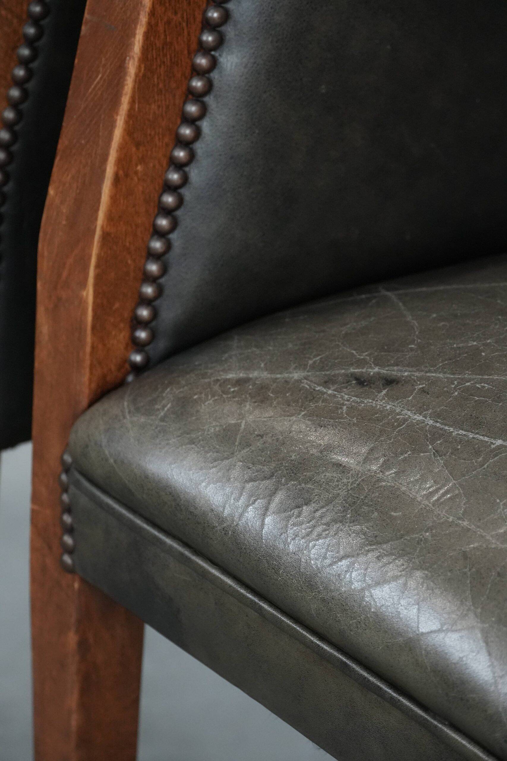 Set of two cowhide and wooden tub chairs with a sturdy colour scheme