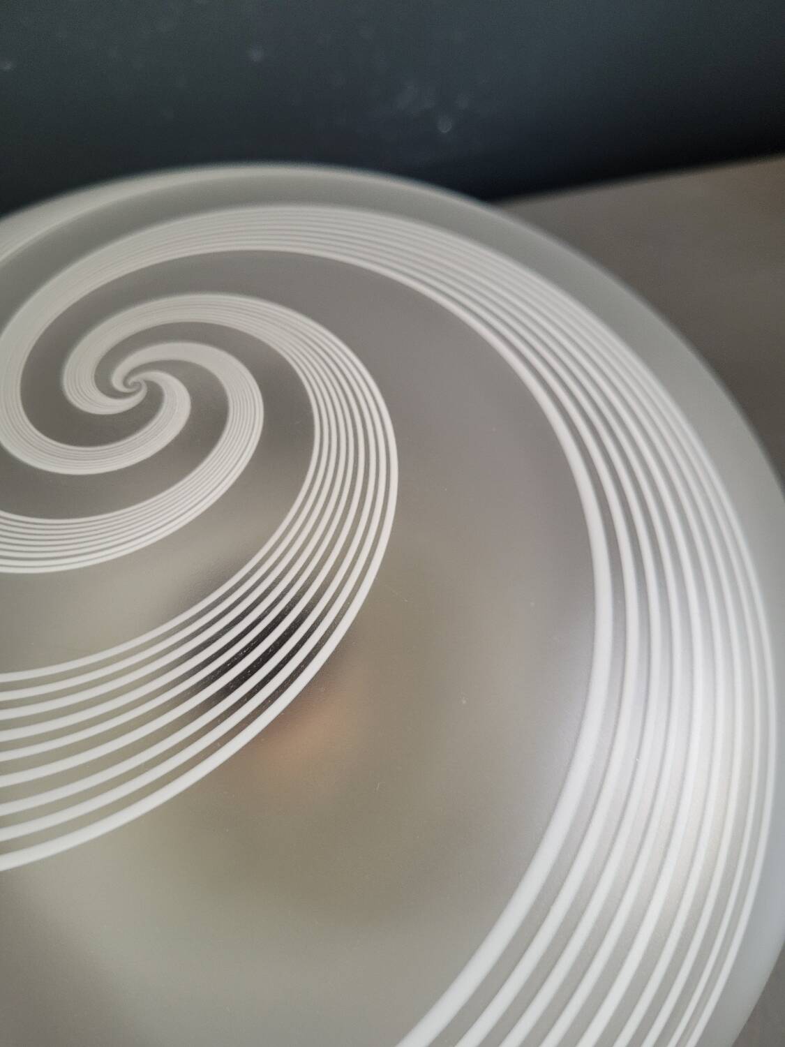 Frosted glass globe ceiling light with spiral patterns.