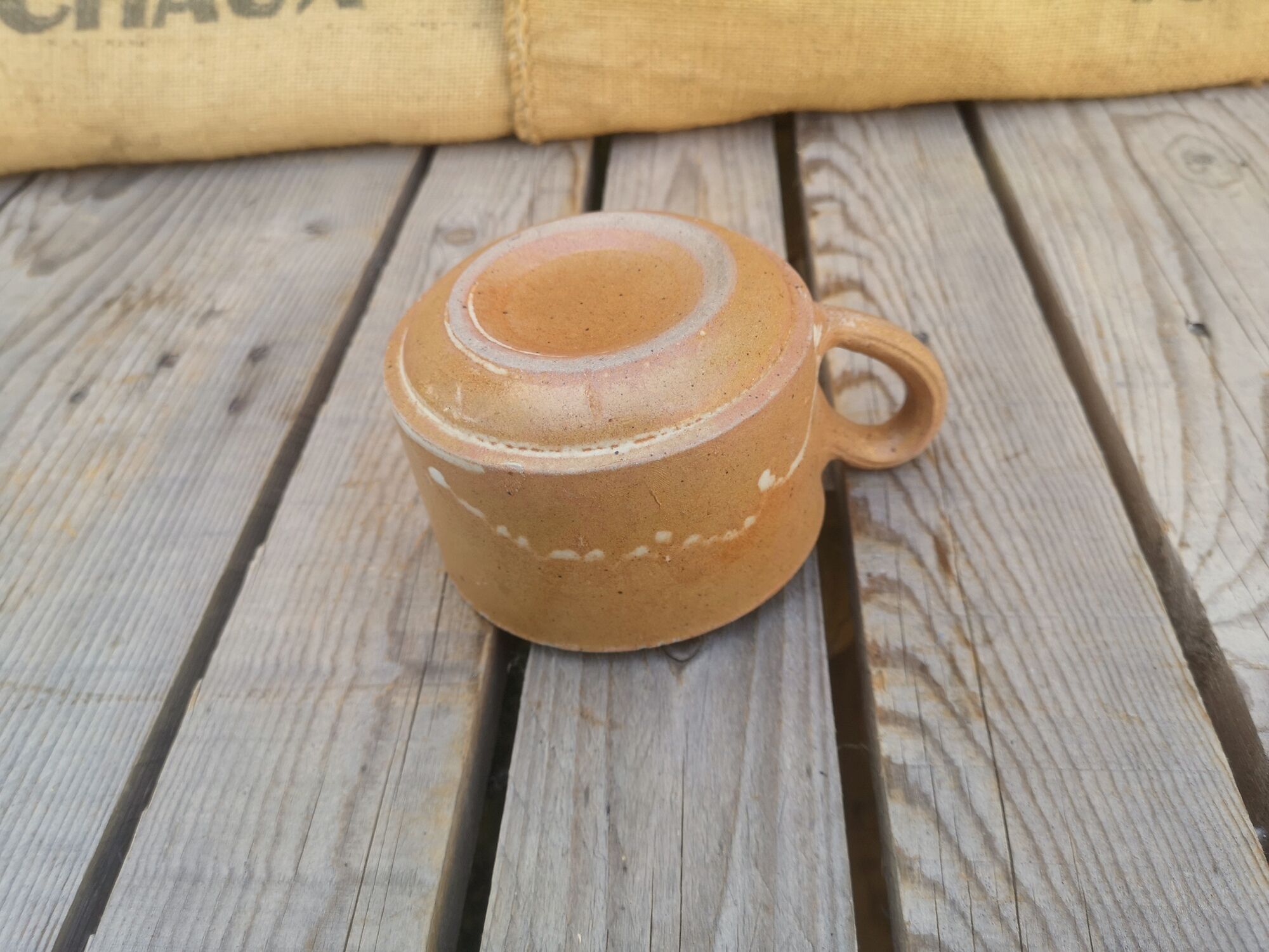 Brown sandstone cup with white spots