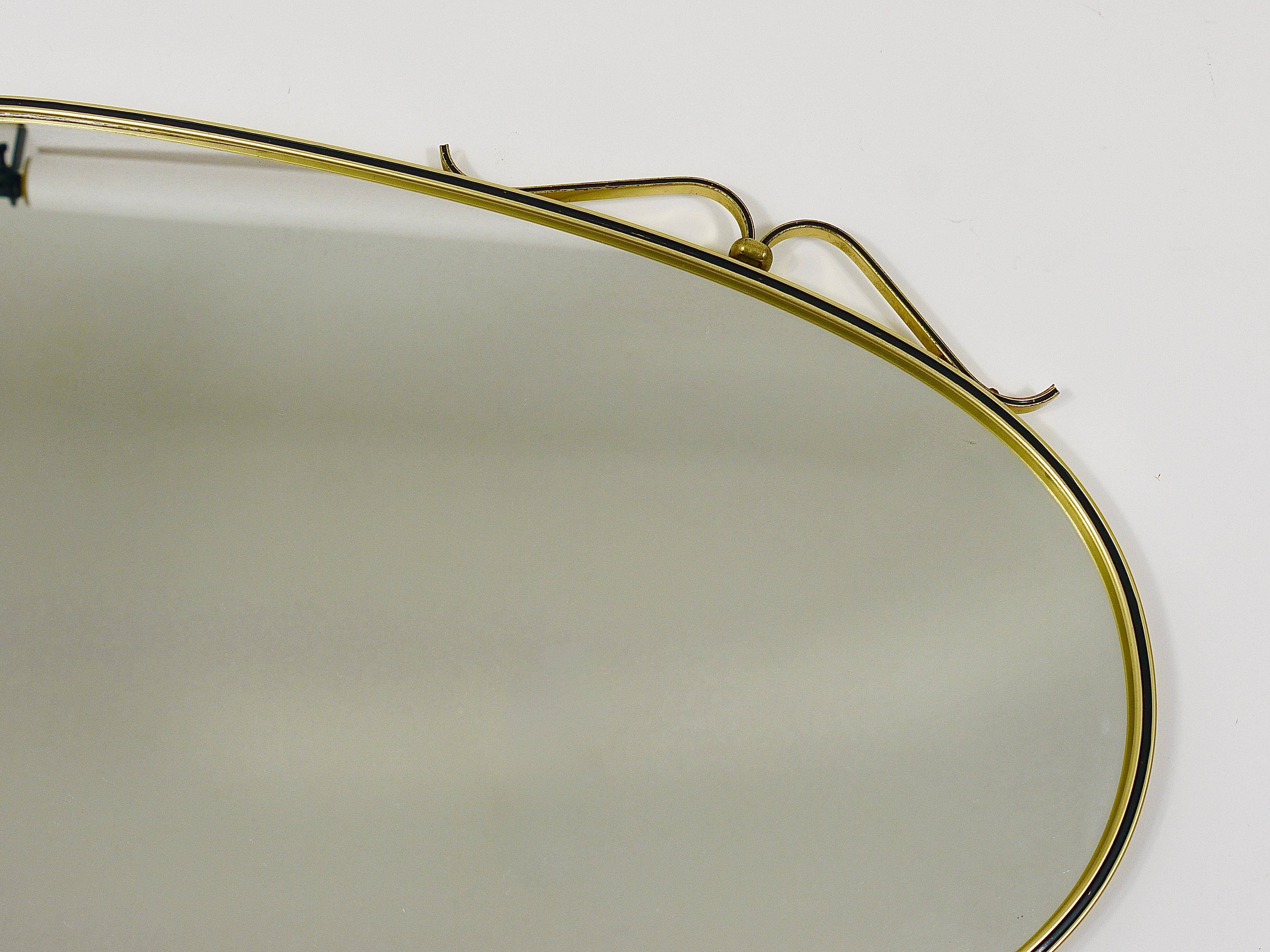 Elegant wall mirror in brass and black from the mid-century, Italy, 1950s.