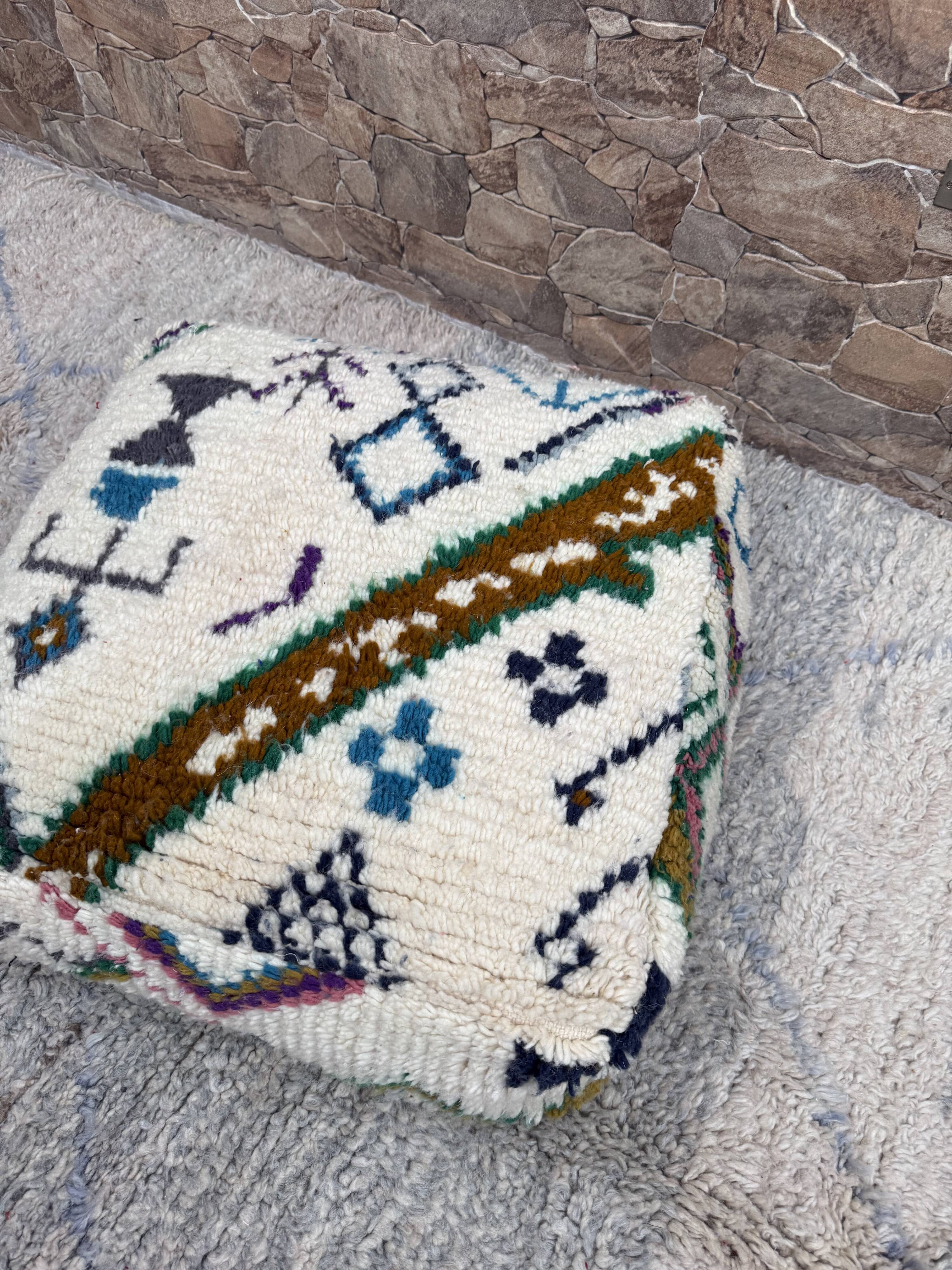 Berber floor pouf: Handwoven Moroccan wool cushion.