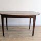 Antique wooden folding table with a patina and brass wheels.