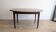 Antique wooden folding table with a patina and brass wheels.