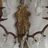 Pair of French antique brass double wall lights with assorted crystals.