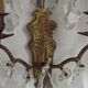 Pair of French antique brass double wall lights with assorted crystals.