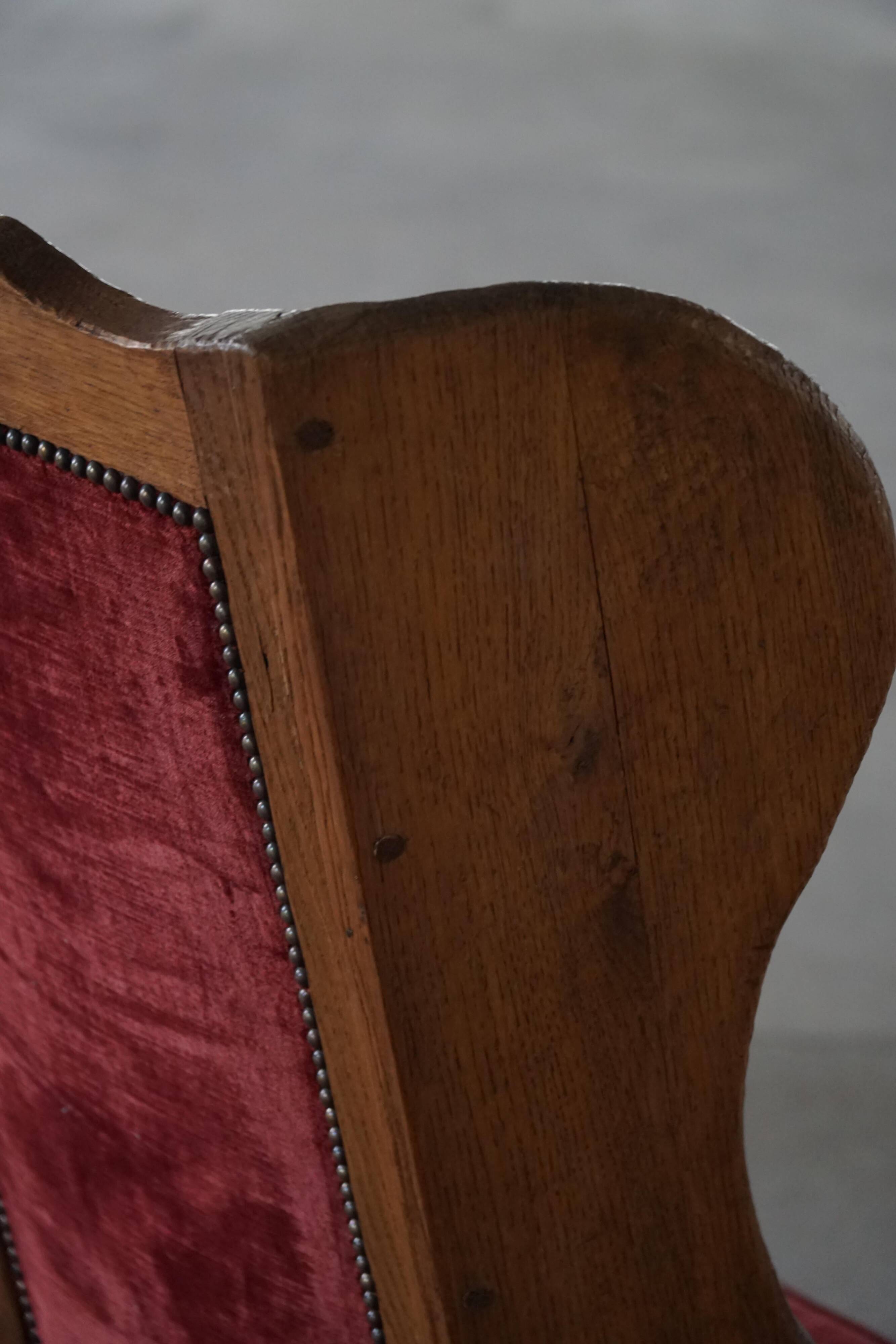 Antique English rocking chair in wood with red velvet upholstery, 19th century.