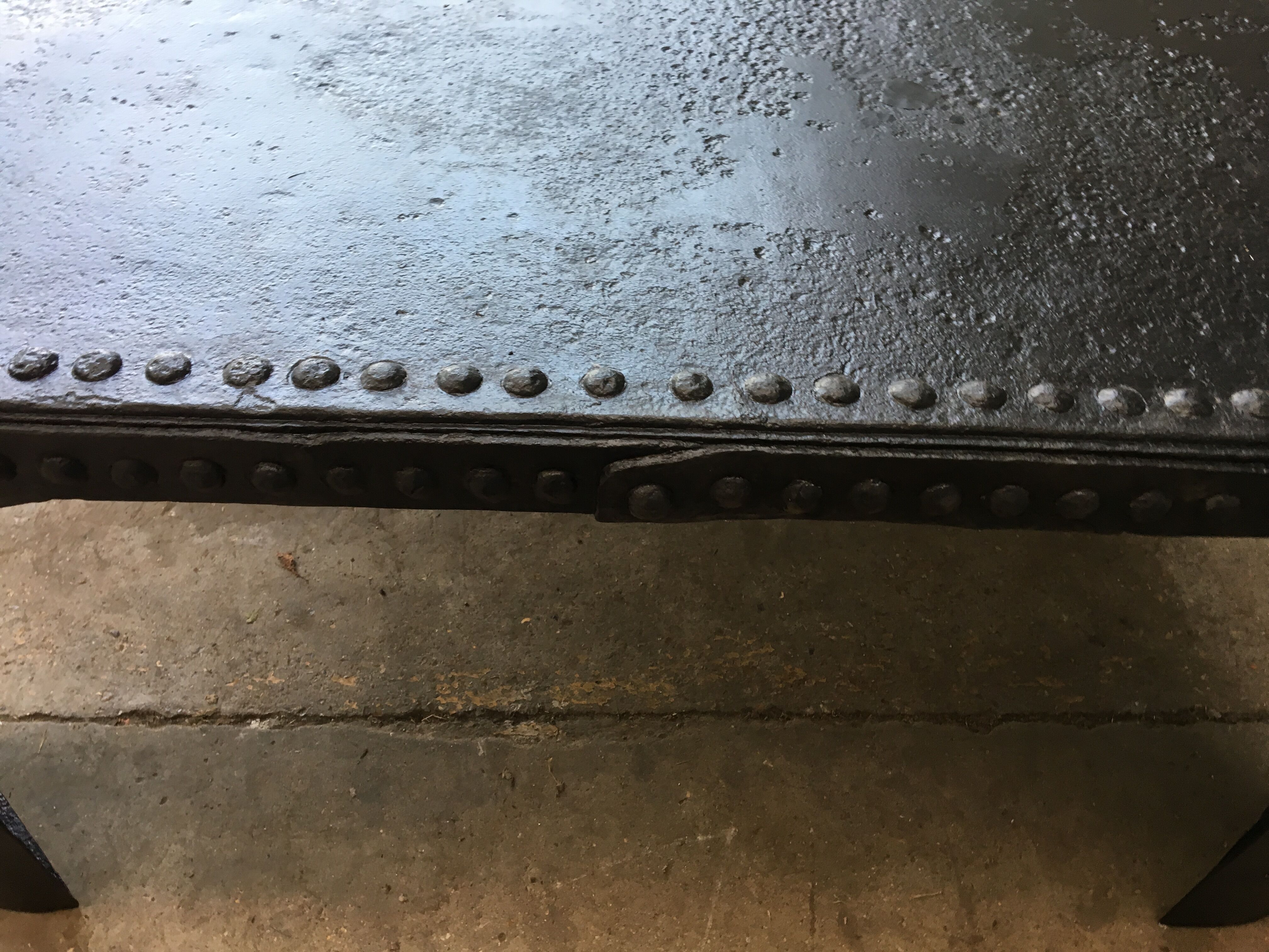 large industrial table in graphite black riveted metal