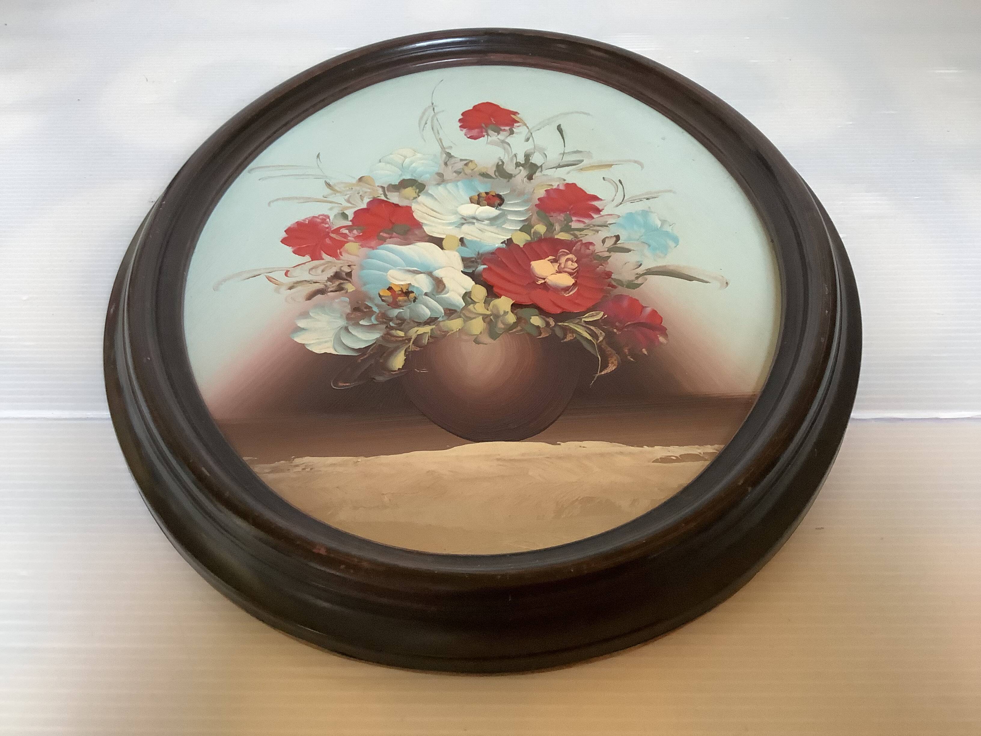 Oval painting of a bouquet of flowers, oil on panel.