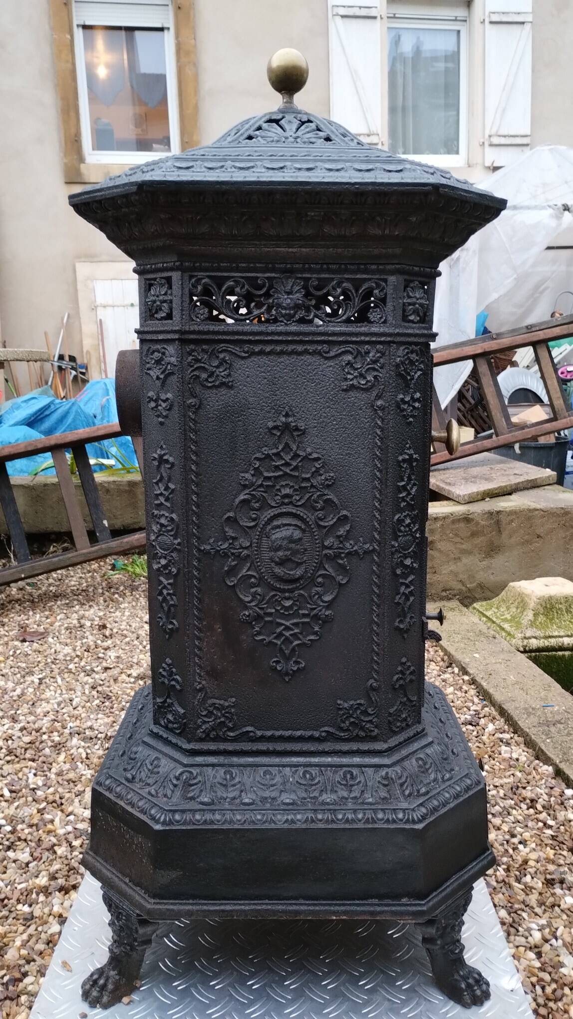 Black cast iron wood burning stove with solid brass handle.