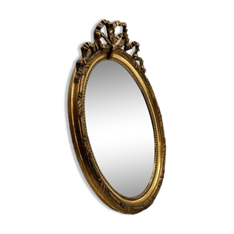 Antique oval gilded mirror with wooden frame and stucco detail