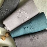 Set of four old damasked and monogrammed towels, tinted multiple colors