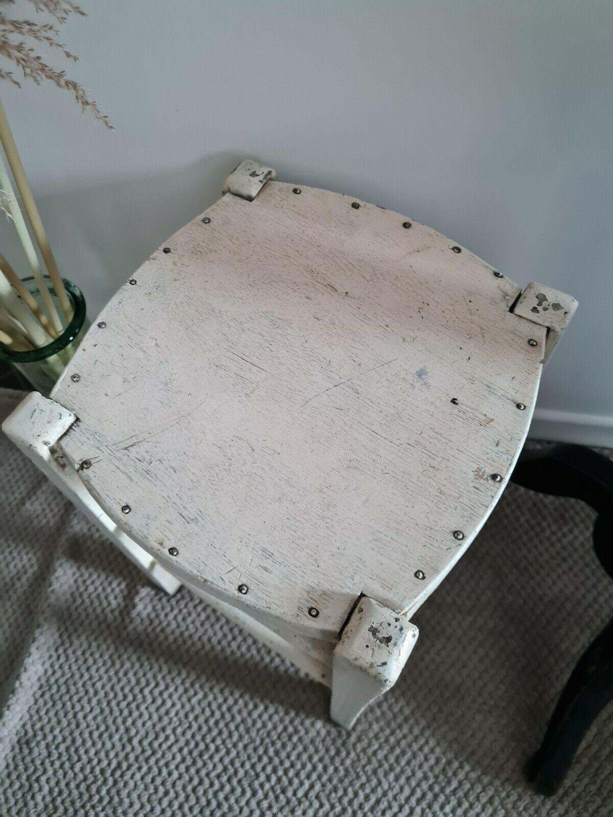 Vintage wooden stool with white peeling paint
