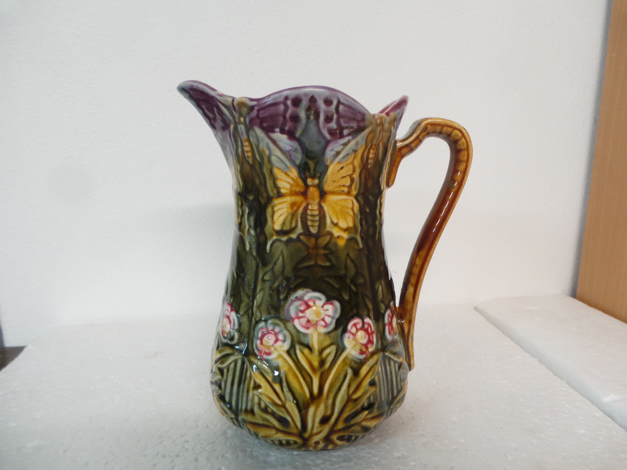Pitcher dabbling in butterfly and flower decoration