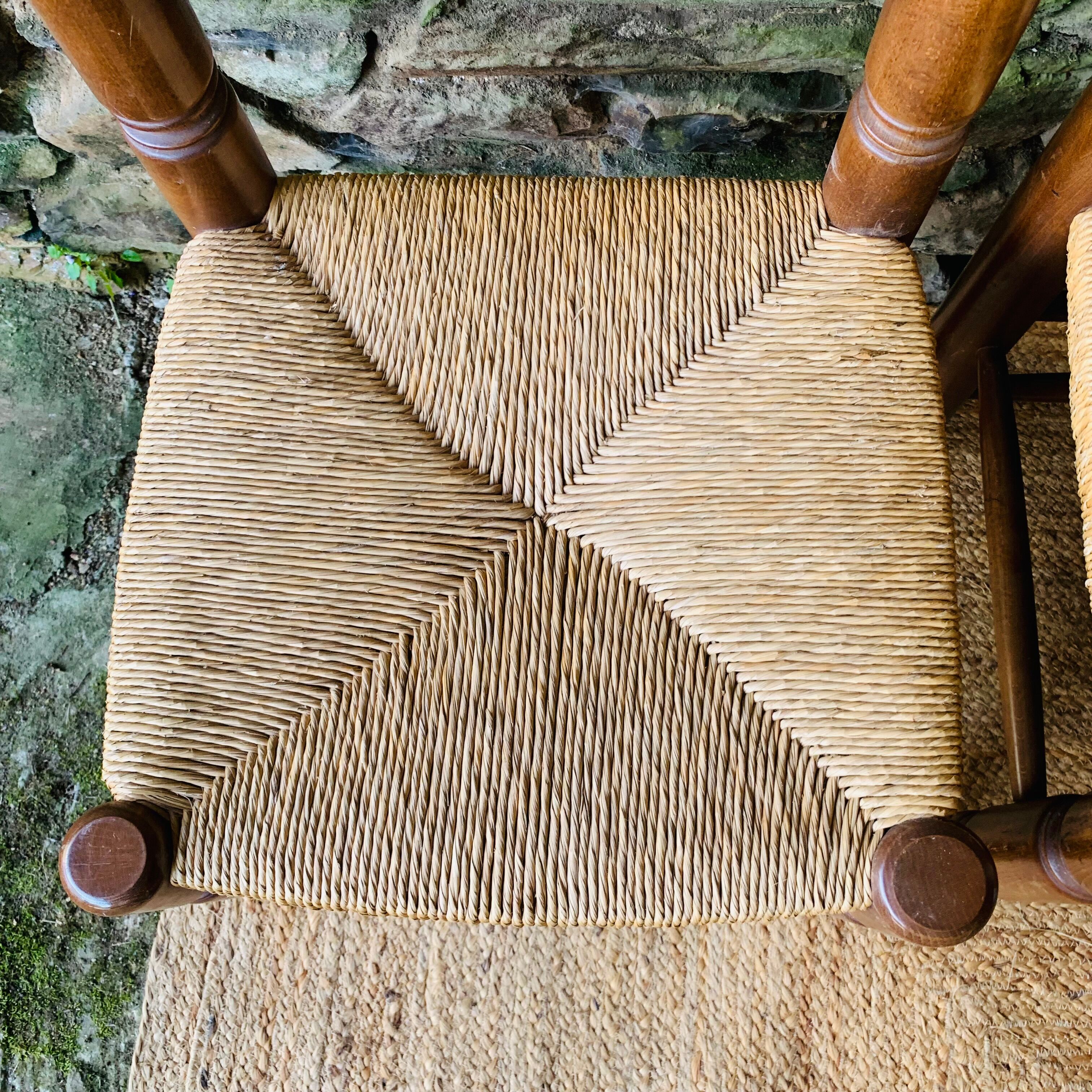 Set of 4 solid wood chairs with straw seats.