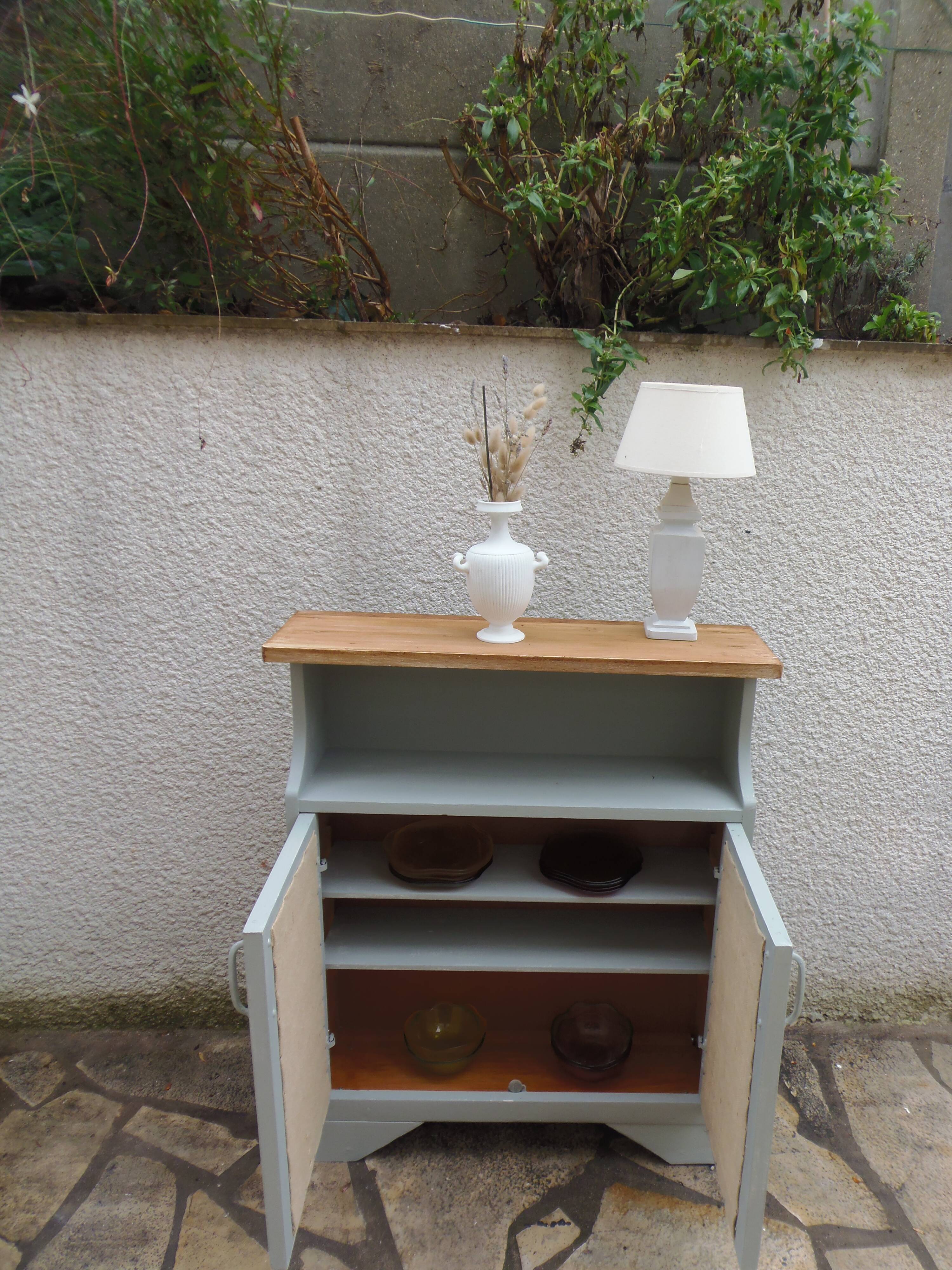 Small vintage green-grey piece of furniture, with 2 doors covered in burlap.