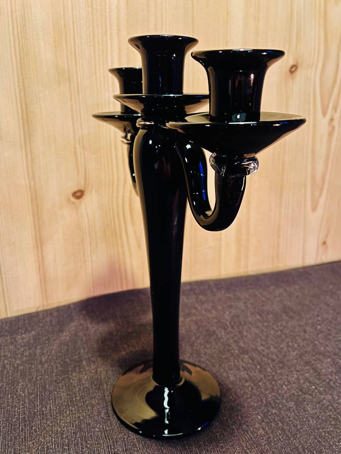 Set of four black glass candle holders.