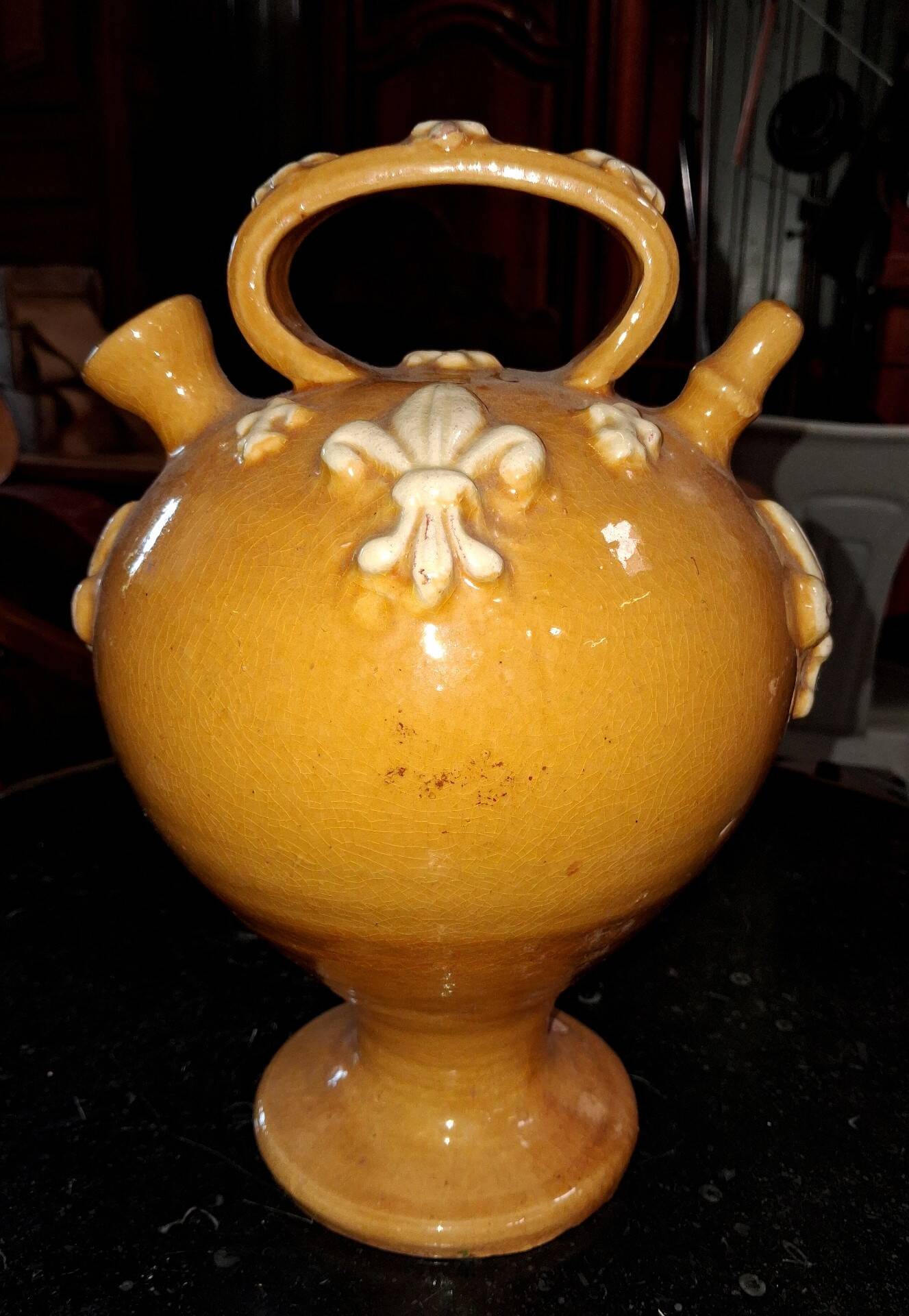 Glazed terracotta gargoyle decorated with fleur-de-lis.