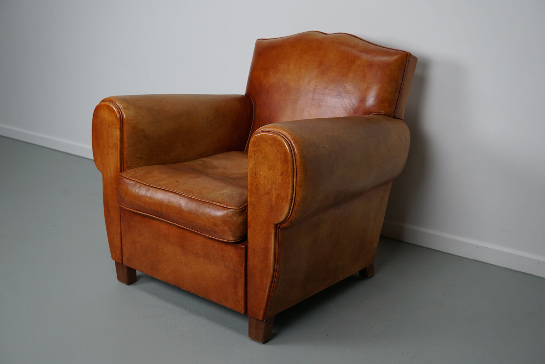Vintage french moustache back cognac-colored leather club chair
