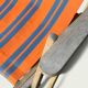 Vintage deck chair with orange and grey striped fabric, original patina.