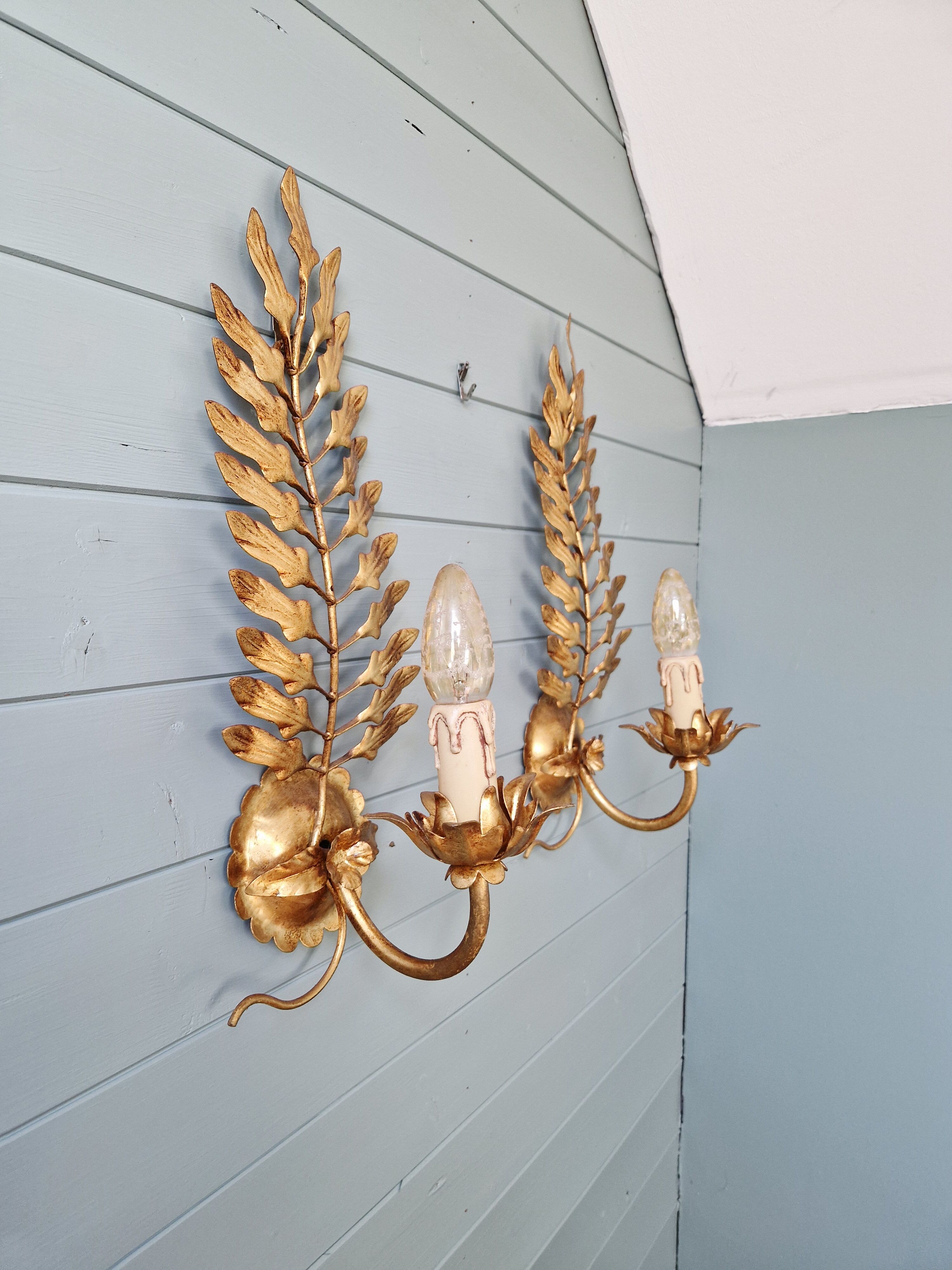 Pair of gold metal wall sconces in Hollywood Regency style, 1970s.