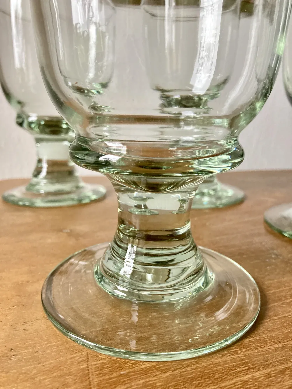 4 stemmed glasses made of handcrafted blown glass in green hue.