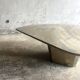 Light gray solid granite coffee table with organic triangular shape and conical base, 1980s