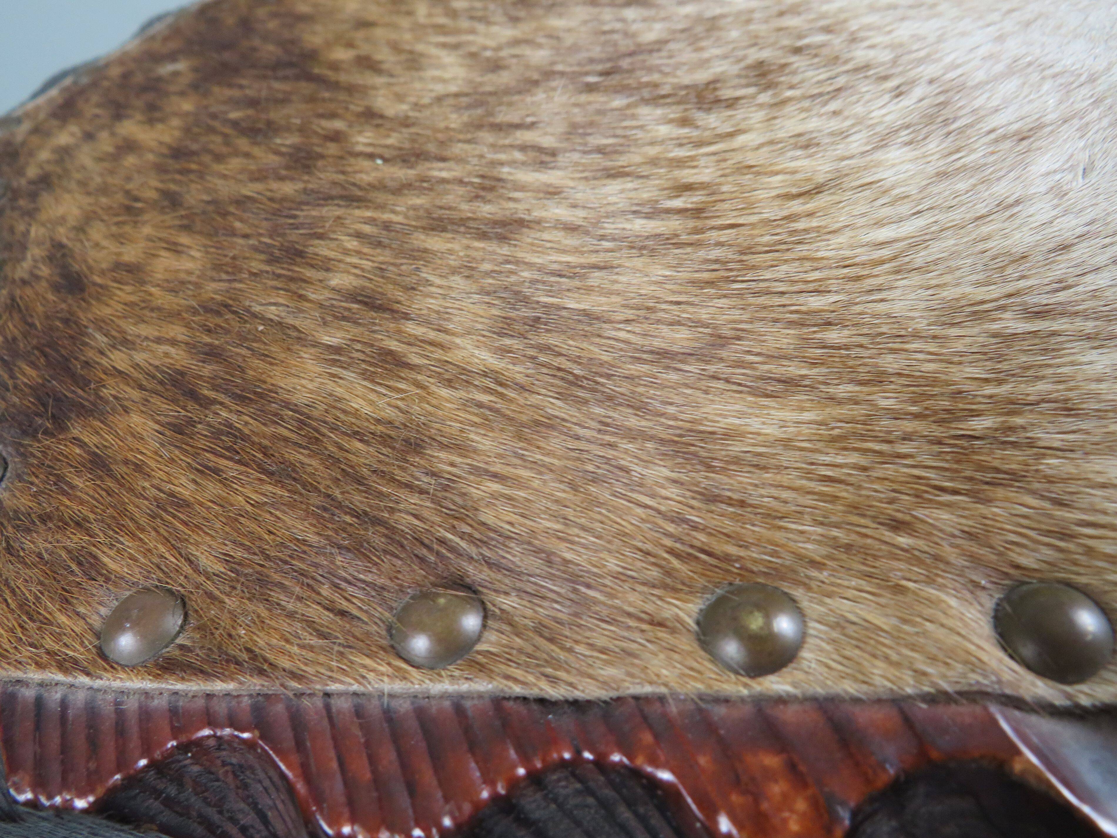 Vintage Spanish stool in carved wood with a leather seat.