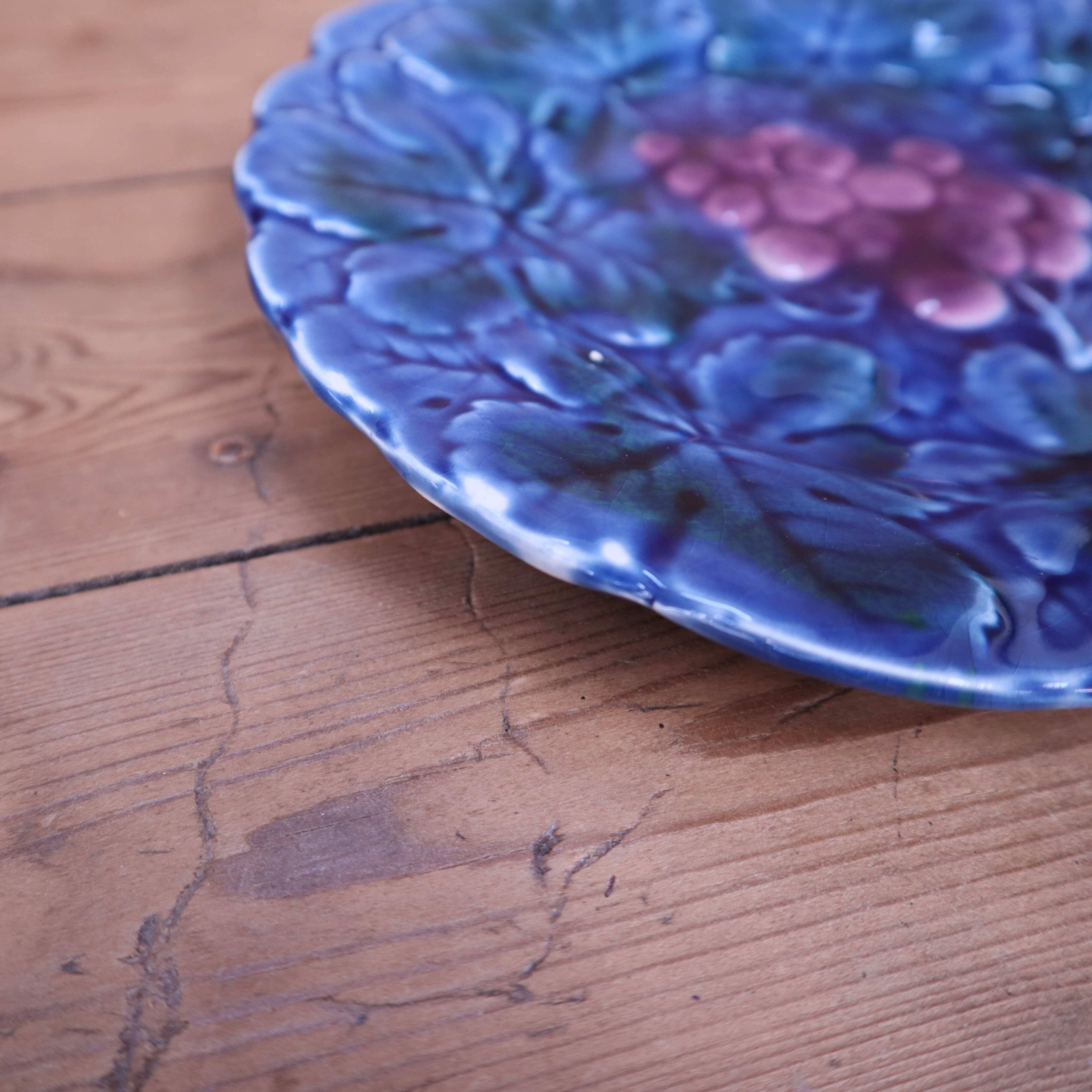Assiette en barbotine bleue à décor de grappe de raisin Sarreguemines