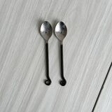 Two small hammered metal teaspoons with a snail pattern.