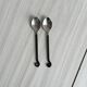 Two small hammered metal teaspoons with a snail pattern.