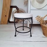 Black iron stool/pouf with its boucle fabric cushion.