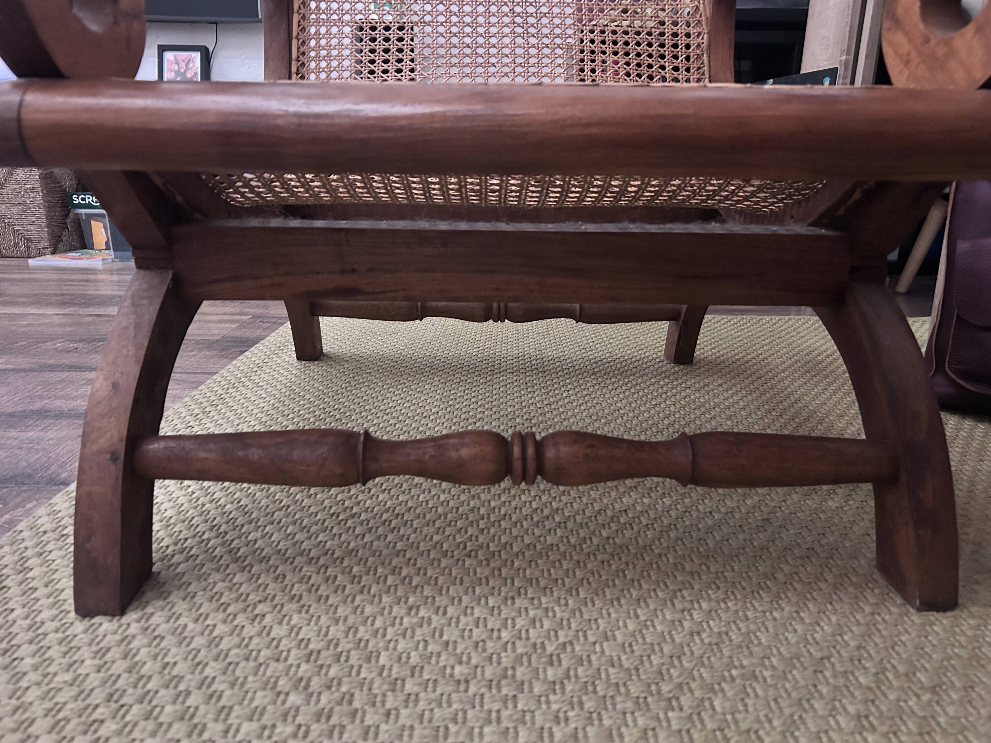 Colonial planter's armchair in solid teak, scroll armrests, caned seat.