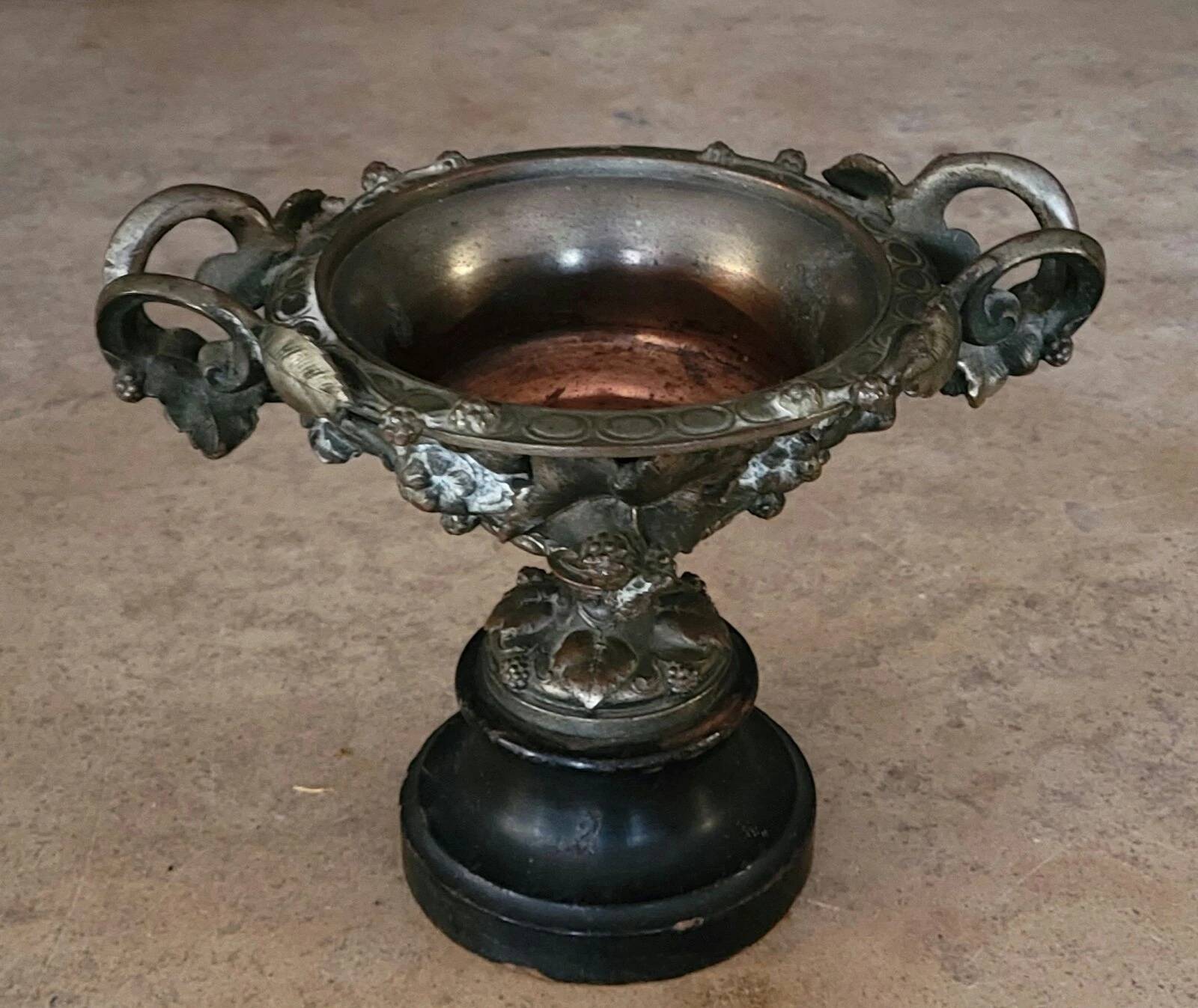 Patinated bronze cup, richly decorated with foliage and bunches of grapes