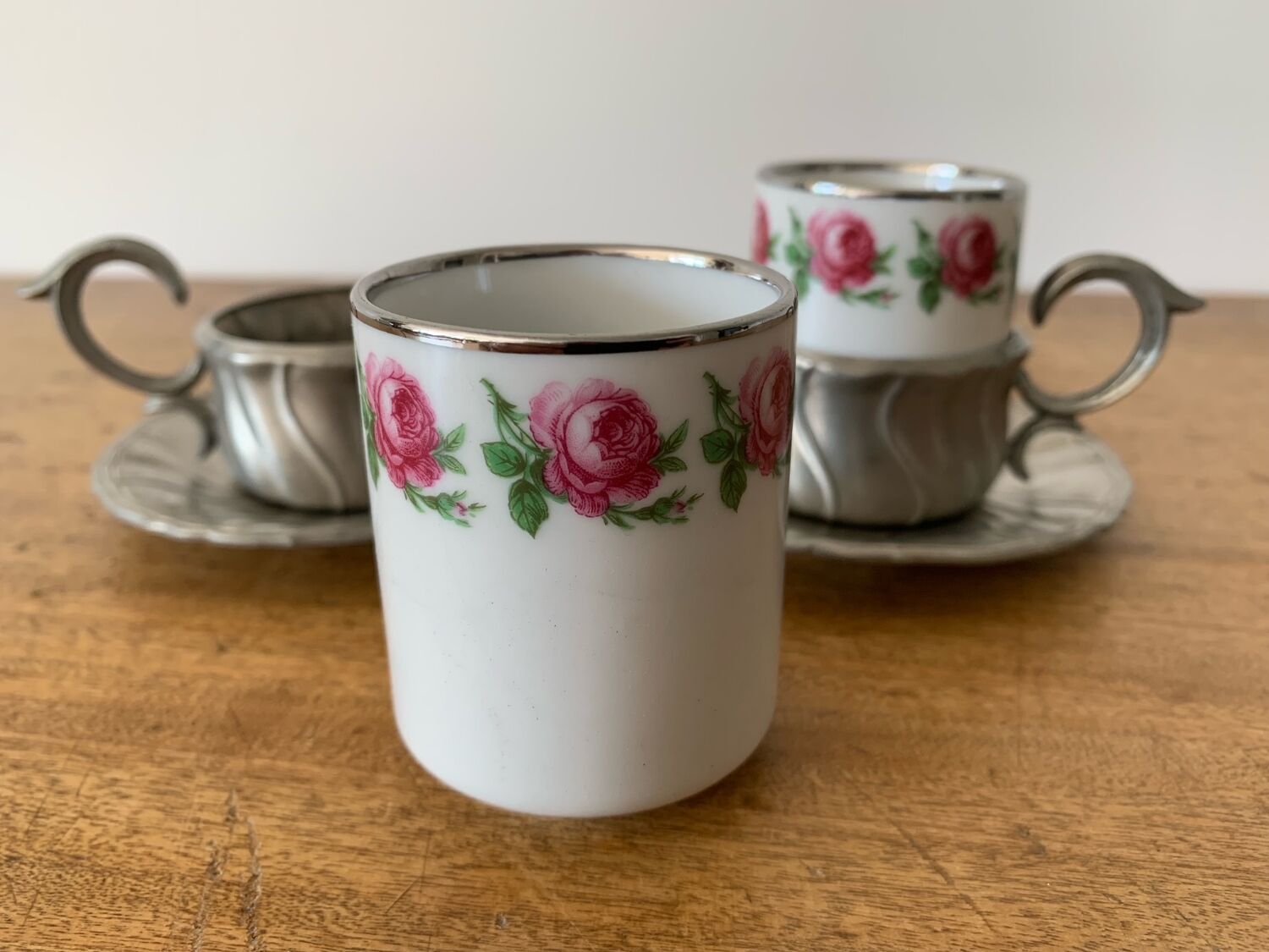 2 small porcelain cups and their pewter cup holders
