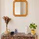 Octagonal mirror in light wood with grooves.