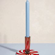 Murano glass candlestick with swirling red and blue ribbons.