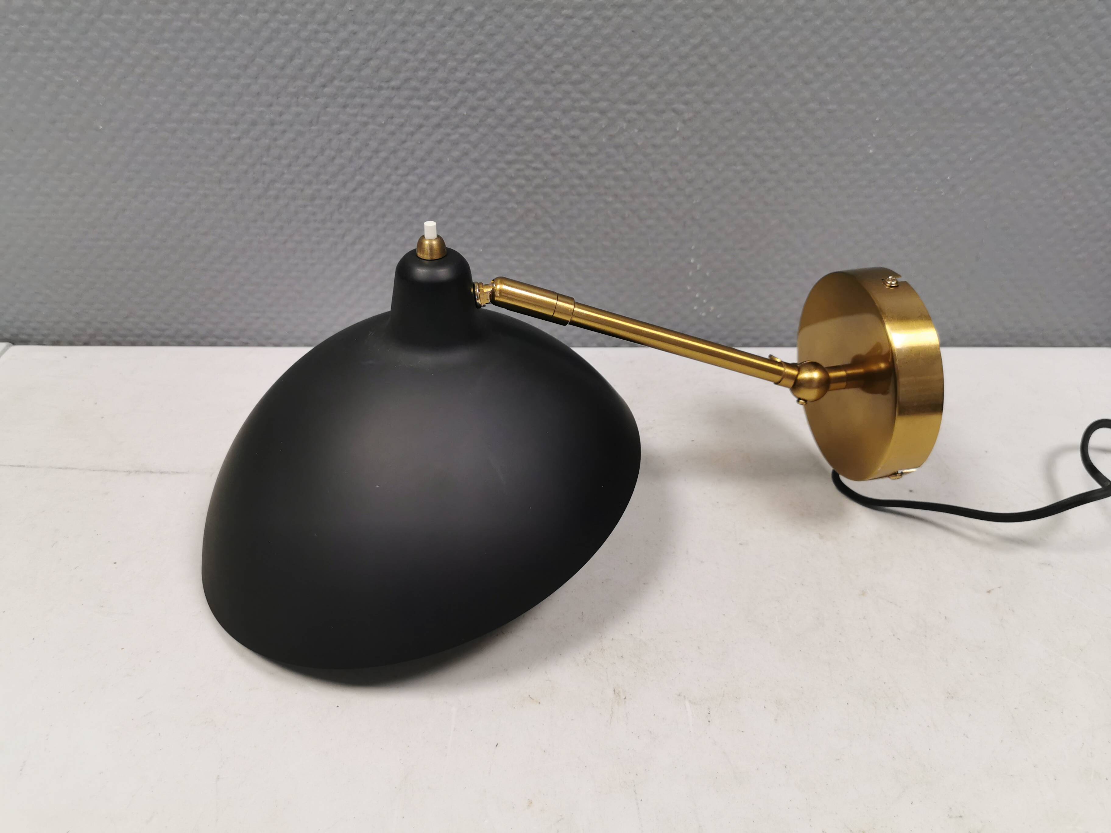 A wall lamp in black and brass-coloured finishes. Danish, early 2000s.