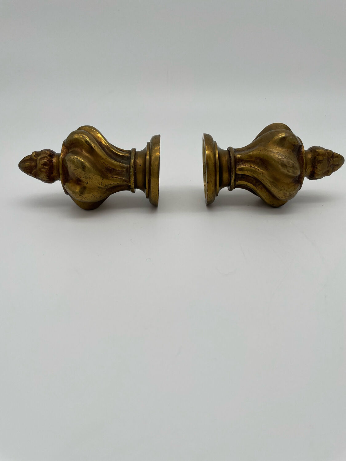 Pair of antique flame curtain rod finials in gilded bronze